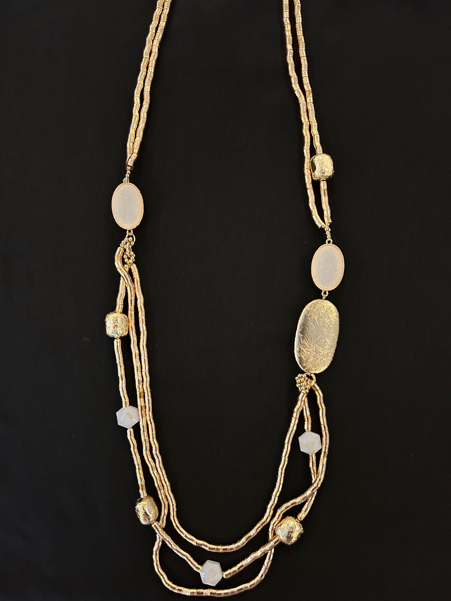 collar dorado con colgante circular u detalles en blanco