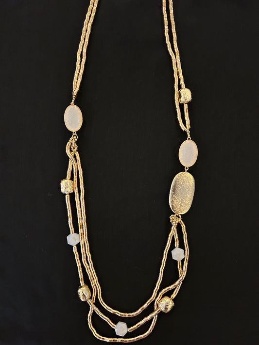 collar dorado con colgante circular u detalles en blanco